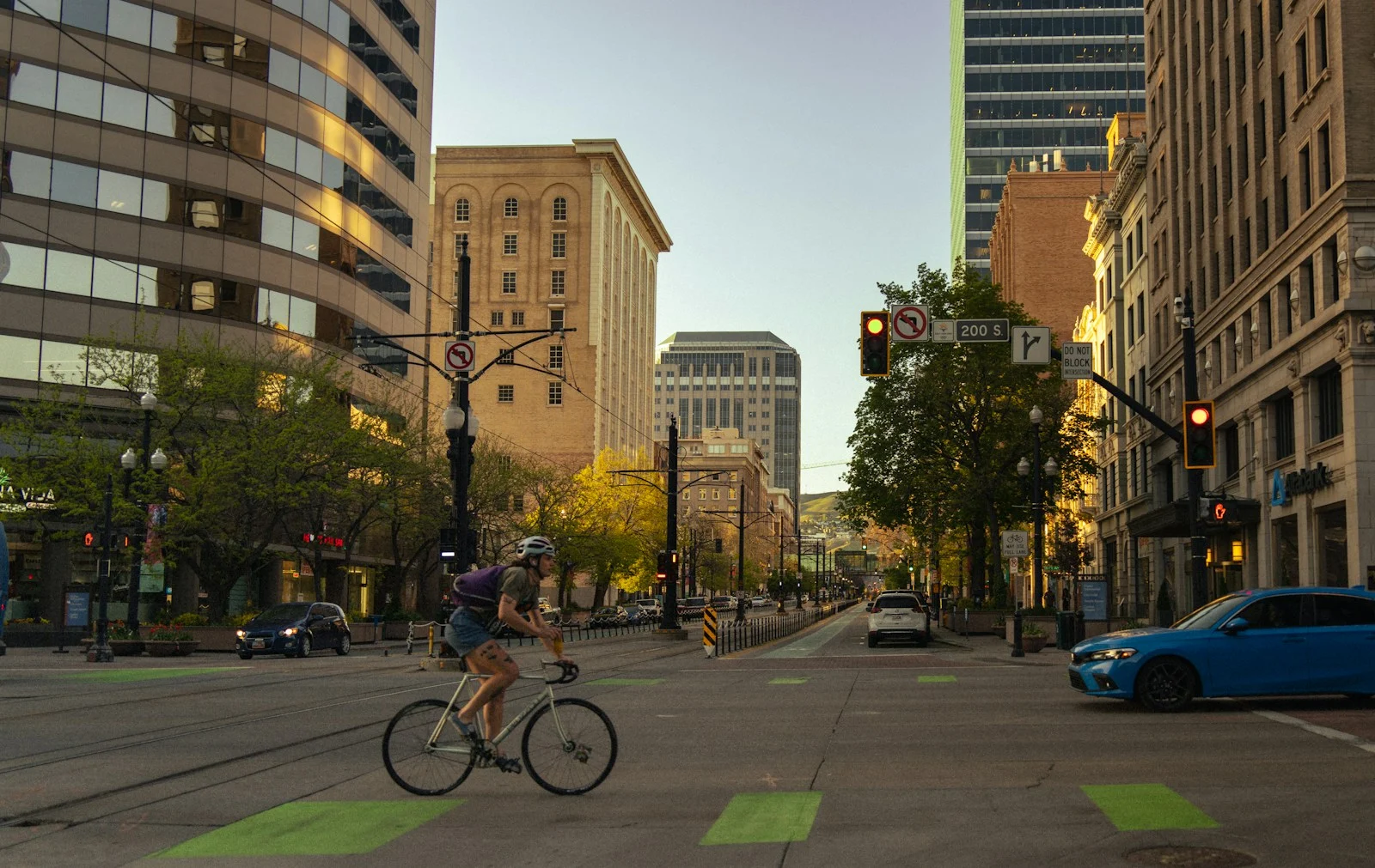 Photo by Alex Moliski A cyclist rides in a city with tall buildings.