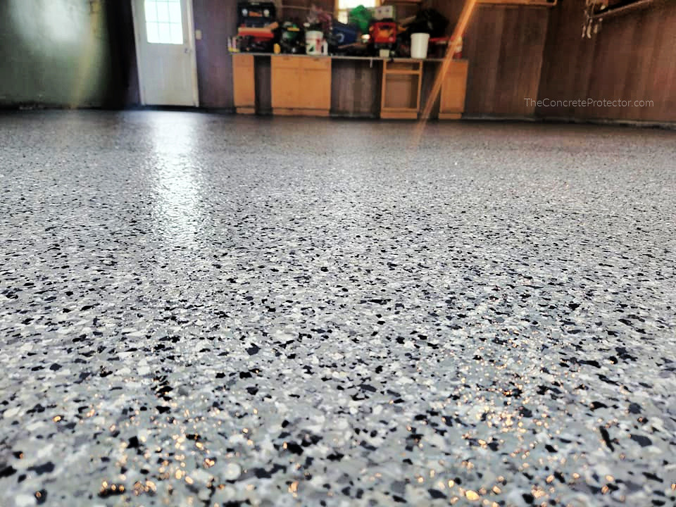 Epoxy Flake Garage Floor- American Dynamic Coatings- Celina, OH Close-up of a speckled gray epoxy garage floor.