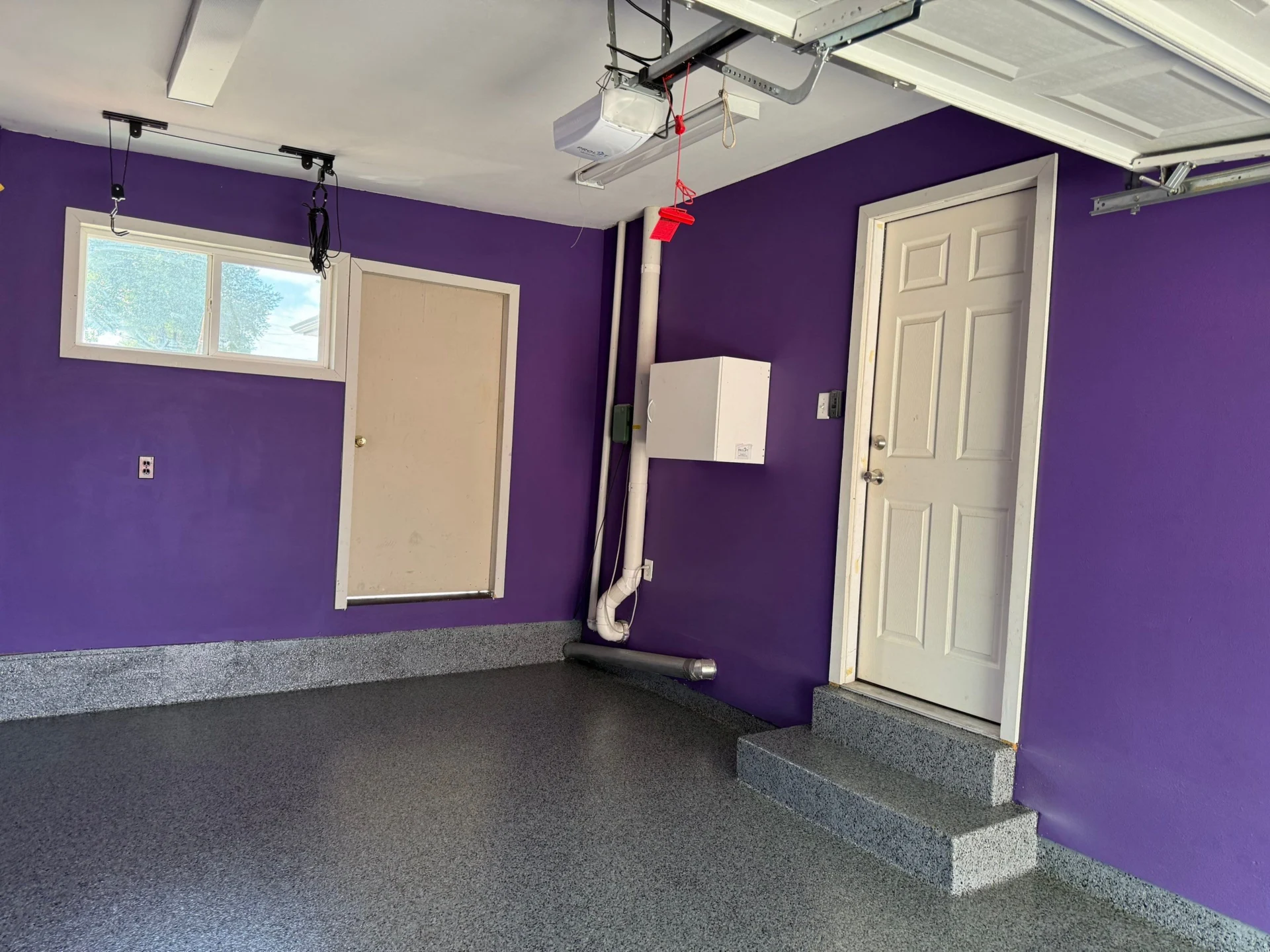 Vibrant purple garage with epoxy floor and white doors