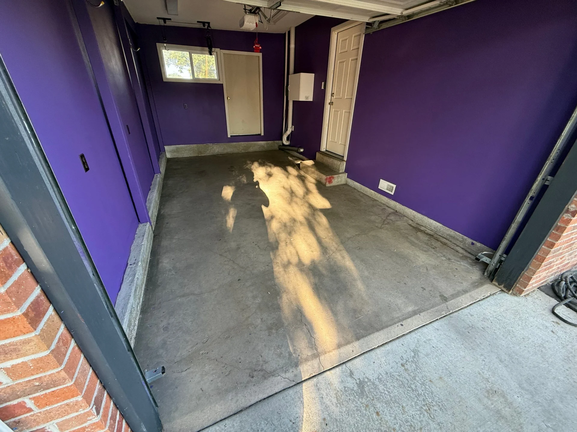 Newly painted purple garage interior with concrete floor.